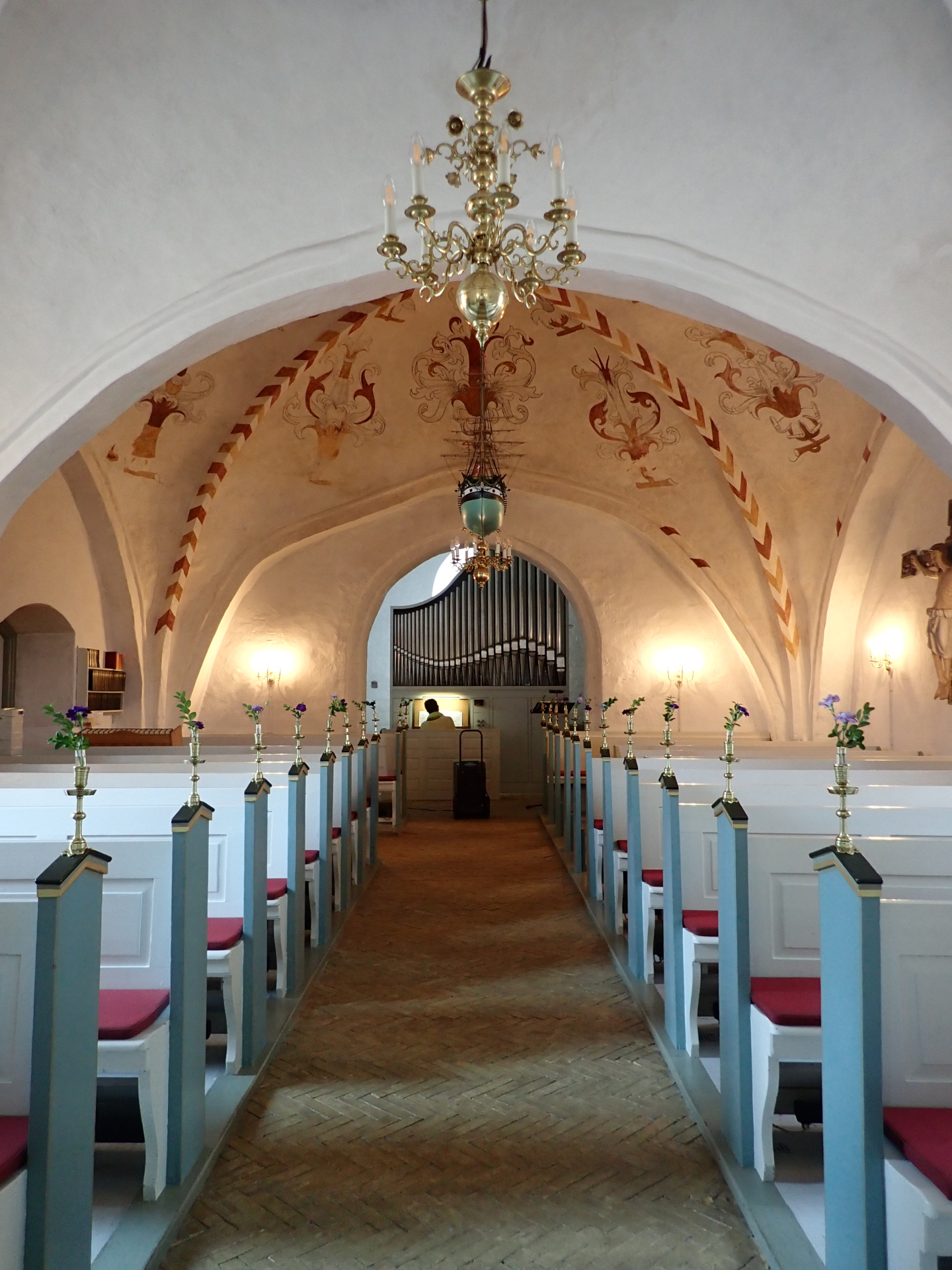 Inside of a church. Someone is playing a small organ