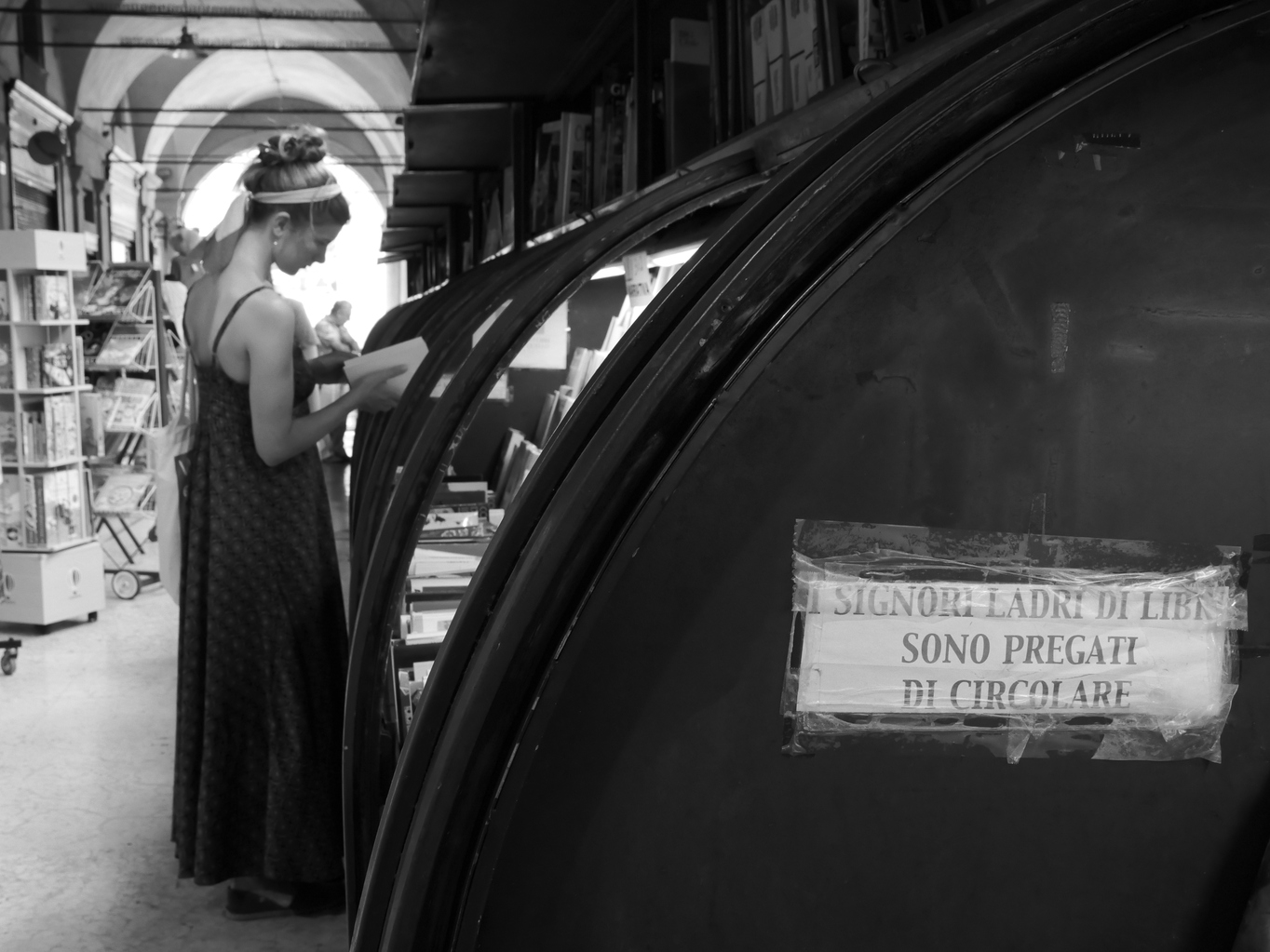 Una ragazza legge sotto i portici della libreria Nanni